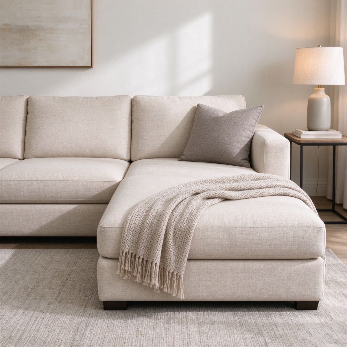 Span L-shaped sofa in beige oatmeal with a knit throw